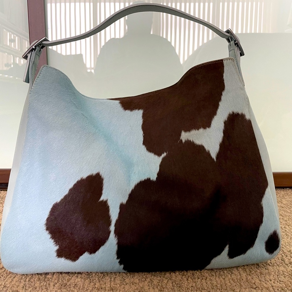 Pony hair hobo bag in blue with brown cow spots.